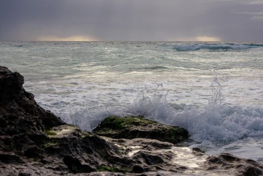 The coastline of the Caribbean Sea with white sand and rocks in Cancun.