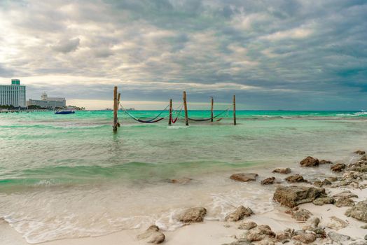 Hammocks hang on poles in the Caribbean.