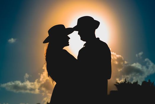 Silhouettes of men and women against the backdrop of the setting sun. Mexico.