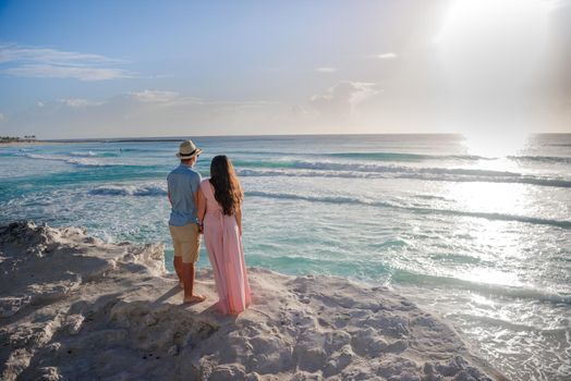 A man and a woman walk on the seashore.