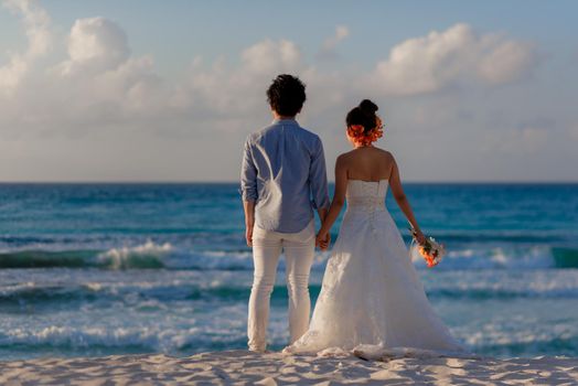 A man and a woman walk on the seashore.