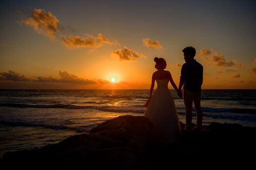 Silhouettes of men and women against the backdrop of the setting sun. Mexico.