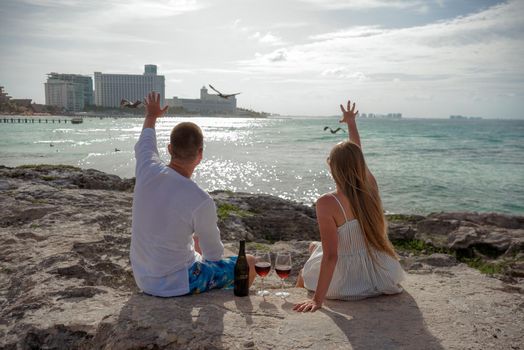 A man and a woman are sitting on the seashore.