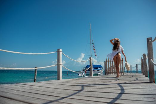 A woman walk on the pier by the sea.