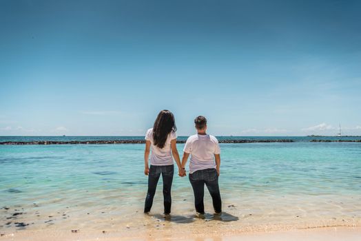 Two woman stand in the sea and look at the horizon. Mexico.