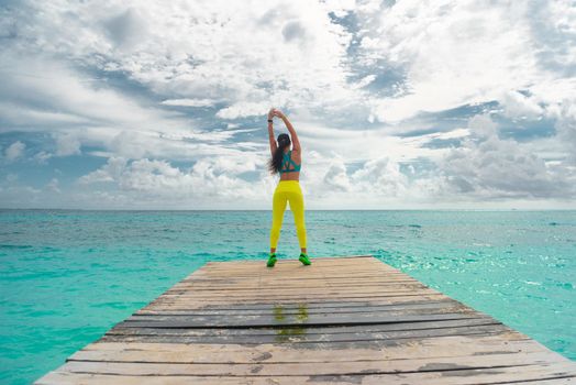 A woman walk on the pier by the sea.