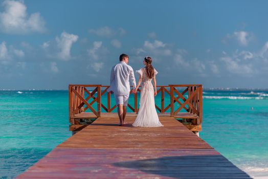 A man and a woman walk on the pier by the sea.