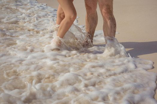 Feet of man and woman in the sand.