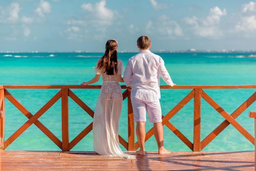 A man and a woman walk on the pier by the sea.