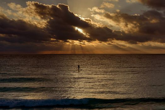 Silhouette of a man on a surf in the sea.