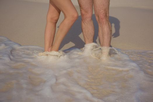 Feet of man and woman in the sand.