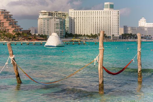 Hammocks hang on poles in the Caribbean.