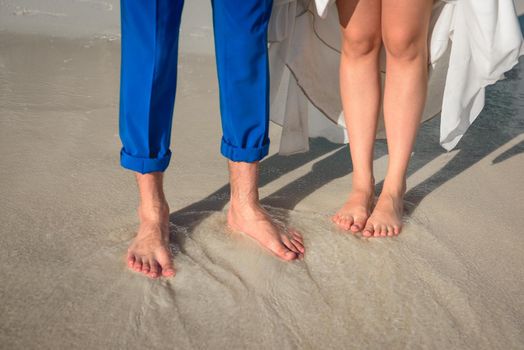 Feet of man and woman in the sand.