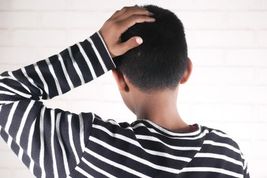 sad teenage boy covering his face sitting on sofa ,