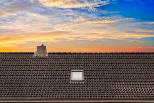 Roof window in velux style with dark roof tiles