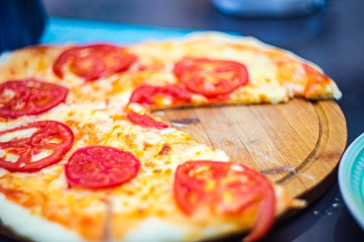 italian pizza with tomato and cheese in pieces