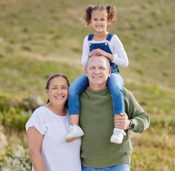 a mature couple spending time outdoors with their granddaughter.