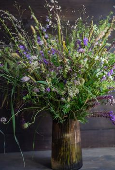 Beautiful wild flowers in bouquet on wooden table