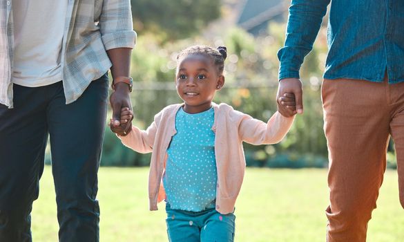 an adorable little girl spending time outdoors with her parents.