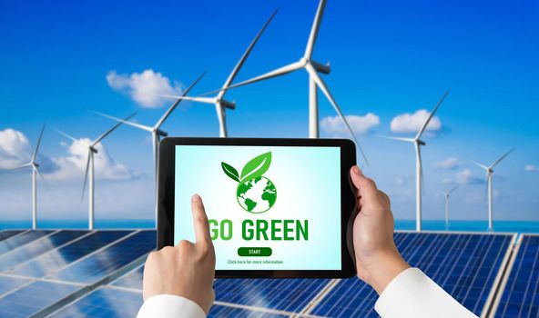 Green business transformation for environment saving and ESG business concept. Businessman using tablet to set corporate goal toward environmental friendly management and alternative clean energy use.