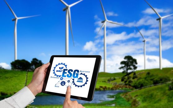 Green business transformation for environment saving and ESG business concept. Businessman using tablet to set corporate goal toward environmental friendly management and alternative clean energy use.