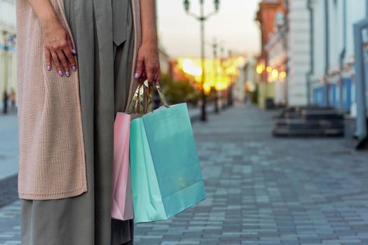 Young beautiful shopper woman smiling happy going to the shops sales holding shopping bags ourtdoors, smiling happy