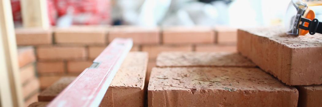 Close-up of blocks placed on unfinished structure, renovation in new apartment. Big concrete wall made of red bricks. Renovation, construction site concept