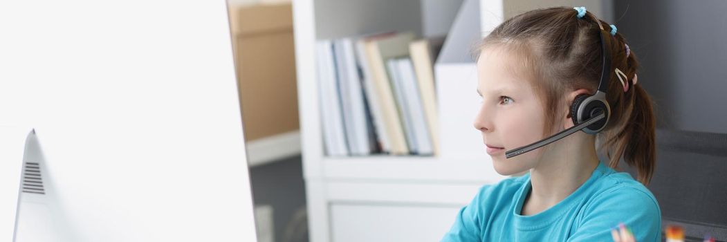 Portrait of girl busy with online school classes from home because of pandemic situation. Child wear headset for better result. Distance education concept