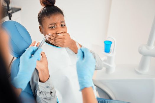 a young woman looking afraid at the dentists office.