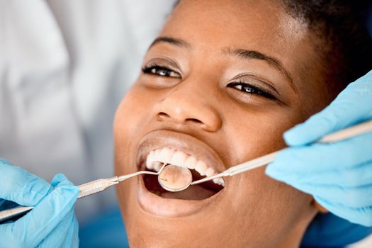 a young female patient having her teeth examined.