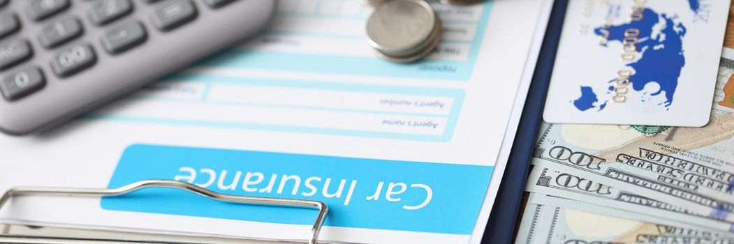 Close-up of car insurance paper calculator stack of coins and banknote on desk. Sign contract and protect your car from accident. Vehicle insurance concept