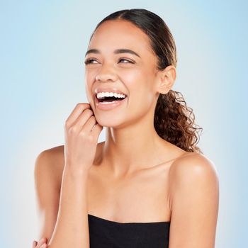 a young woman posing against a blue background.