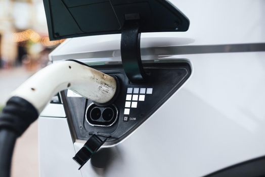 Close up of the power supply plugged into an electric car being charged.