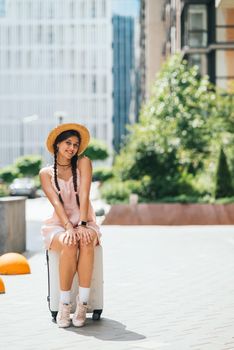Lifestyle and travel Concept: Young beautiful caucasian woman is sitting on suitecase