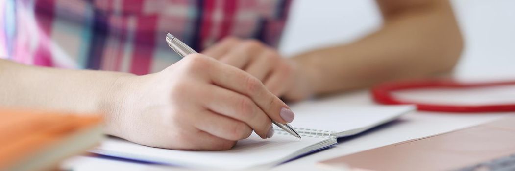 Close-up of person writing down ideas in diary, making notes for future, planning day. Man use for writing silver pen. Journal, creativity, writer concept