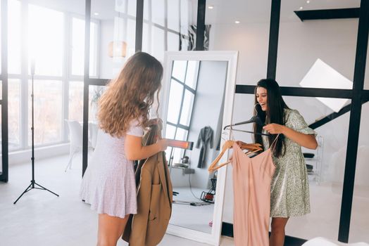 Image of pretty females trying on dress at home