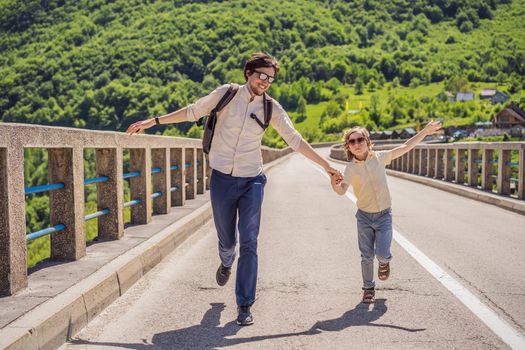 Montenegro. Father and son tourists in background of Dzhurdzhevich Bridge Over The River Tara. Travel around Montenegro concept. Sights of Montenegro.