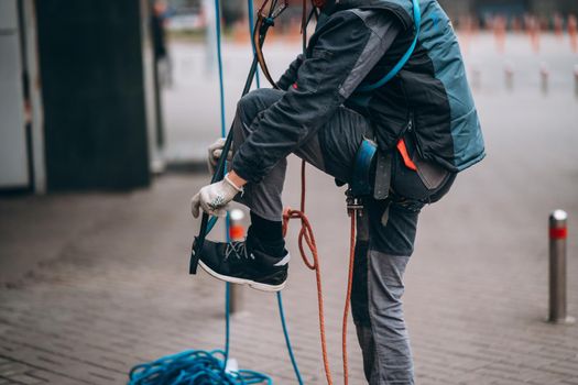 Worker climber preparing for work. Climber tightens the safety belt and check fixing and carbines