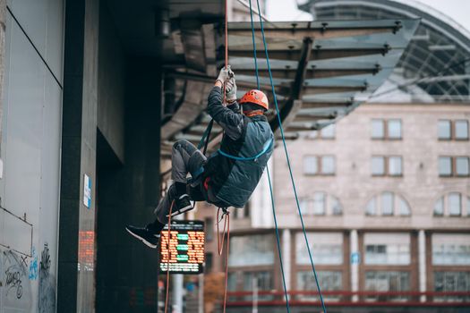 Industrial climber in uniform and helmet rises. Outdoor