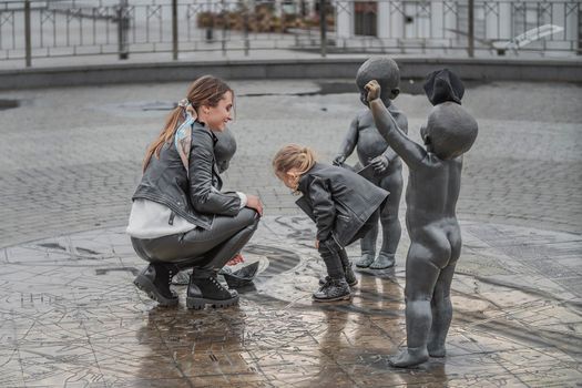 mother plays with her daughter in the city