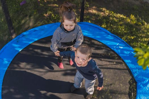 top view of small children jumping on a trampoline