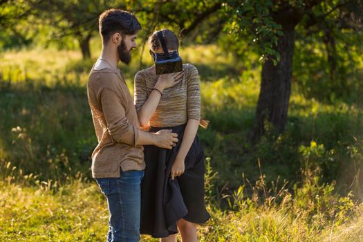 couple in nature, girl in virtual reality glasses close-up