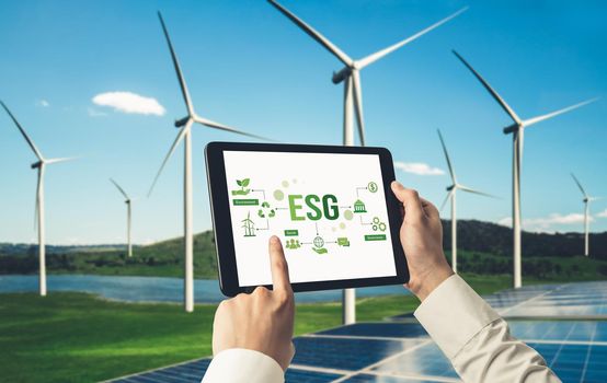 Green business transformation for environment saving and ESG business concept. Businessman using tablet to set corporate goal toward environmental friendly management and alternative clean energy use.