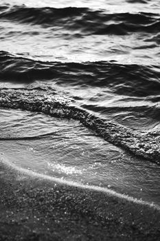 Sea waves and sand in sunshine glow at sunset, black and white art print, sandy beach and coastal nature concept