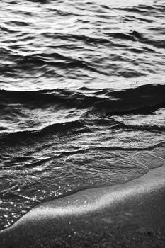 Sea waves and sand in sunshine glow at sunset, black and white art print, sandy beach and coastal nature concept