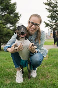 Happy woman walking with bull terrier in park