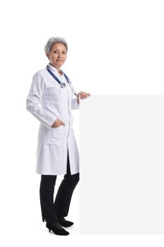 Mature asian female doctor holding blank banner with copy space for text isolated on white background