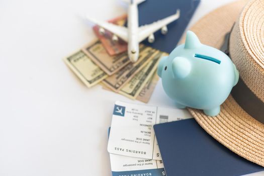 Save money for airplane tickets, planning travel budget concept. Airplane model, piggy bank on wooden table.