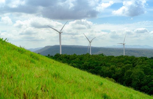 Wind energy. Wind power. Sustainable, renewable energy. Wind turbines generate electricity. Windmill farm on a mountain with blue sky. Green technology. Renewable resource. Sustainable development.