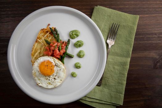 Fried egg with hashbrowns, asparagus, tomatoes and avocado sauce.